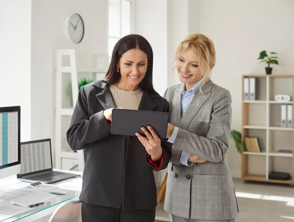 Portrait of young cheerful female business people employees standing on workplac